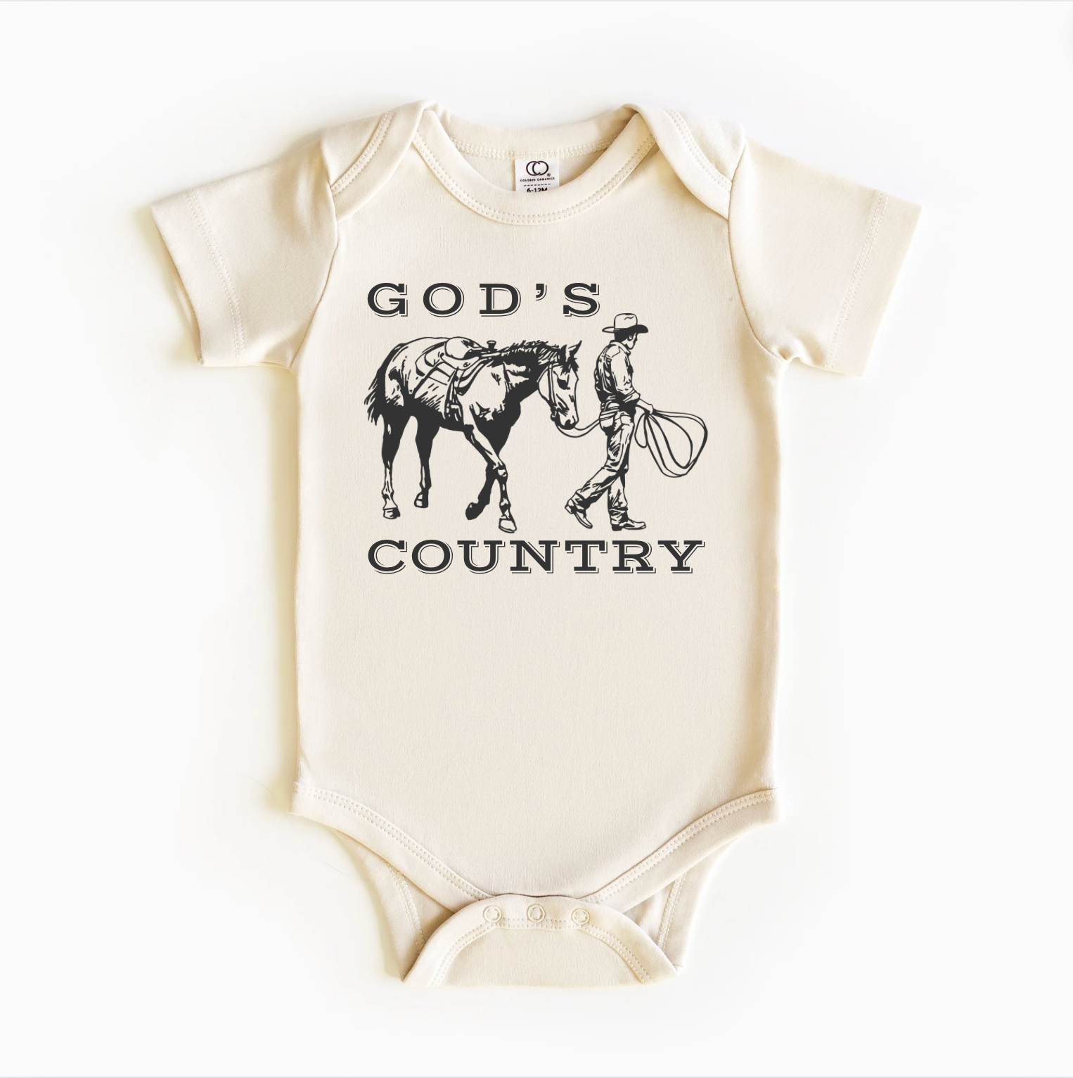 A white bodysuit onesie with 'GOD'S COUNTRY' printed in black. The design includes an illustration of a horse and a cowboy riding a horse.