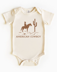 A beige bodysuit with an American cowboy theme, featuring a horse and cactus design, on a short-sleeved pattern.