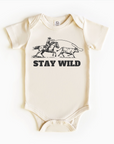 A beige bodysuit with 'Stay Wild' text and a graphic of a cowboy riding a horse on the front.