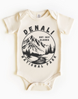 A beige bodysuit with a black and white print of Denali National Park, Alaska on the front.
