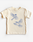 A light-colored, unisex gender neutral tee shirt top with a blue bird design on it, displayed on a white background.
