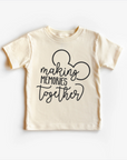 A beige neutral tee shirt top with text 'MAKING MEMORIES TOGETHER' and a silhouette of a mouse character on the front.
