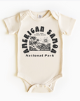 A white bodysuit with a graphic print related to the American Samoa National Park.