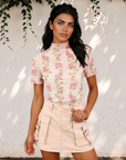 Front view of the Millie short sleeve mesh top with a pink floral print, styled with pale pink shorts.