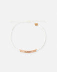 Seek Him cream string bracelet with a gold-tone message bar and small brand charm on a white background