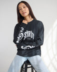 Model wearing the Spirit Is Moving black long sleeve tee with white chest lettering and sleeve graphics