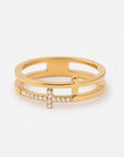 Gold-tone stacked cross ring with layered bands, a polished cross, and a clear gem-accented cross on a white background