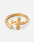 Textured gold-tone cross ring with an open wrap-style band on a white background