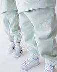 Light blue tracksuit with white sneakers on a white background