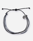 Black braided bracelet with a silver charm on a white background