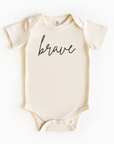 Baby wearing “Brave” affirmation bodysuit – Christian script design organic cotton outfit by Lumiere Vive