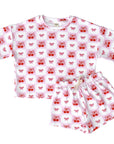 Children's pajama set with red cherry pattern on a white background