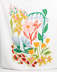 Person holding a large white pillow with colorful floral design on a white background