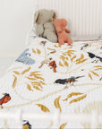 Children's room with a bed featuring animal-patterned bedding and stuffed toys.