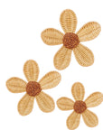 Three woven flower-shaped objects with brown centers on a white background