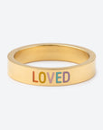 Gold ring with 'LOVED' in colorful letters on a white background