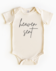 Baby wearing “Heaven Sent” affirmation bodysuit – Christian script design organic cotton outfit by Lumiere Vive