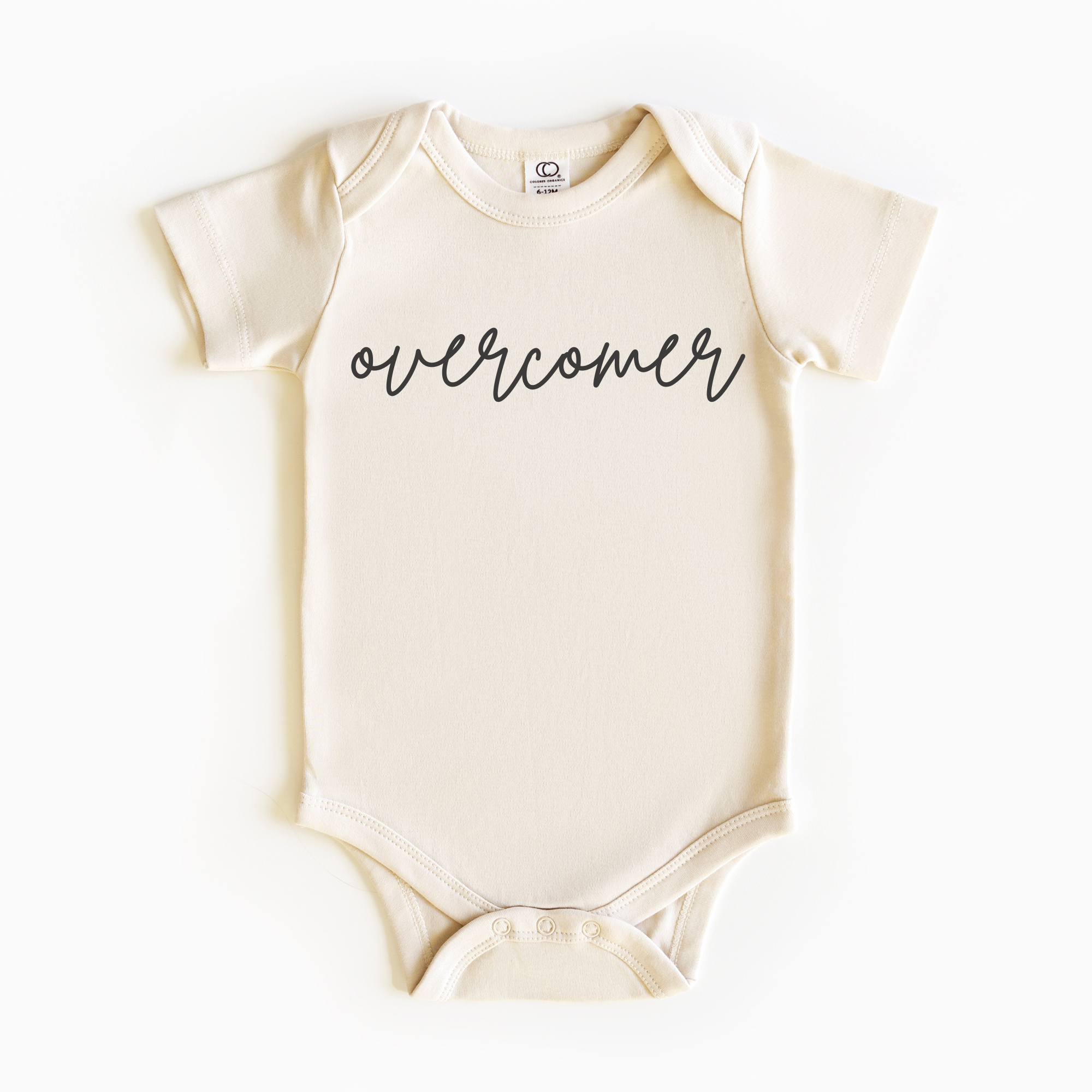 Baby wearing “Overcomer” affirmation bodysuit – Christian script design organic cotton outfit by Lumiere Vive