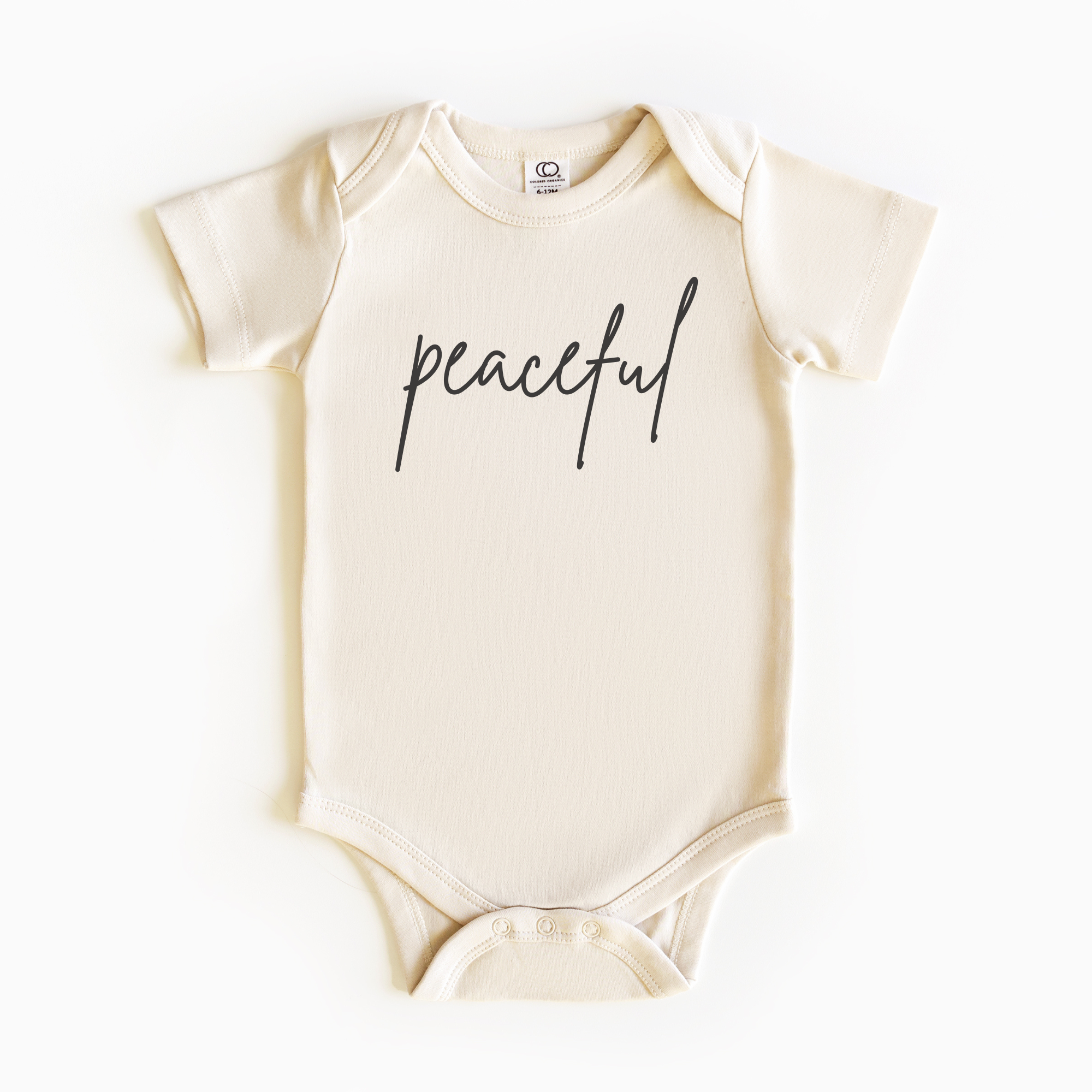 Baby wearing “Peaceful” affirmation bodysuit – Christian script design organic cotton outfit by Lumiere Vive