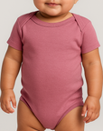 Baby girl wearing the Rabbit Skins 4424EX infant fine jersey bodysuit in Vintage Mauvelous, front view, ideal for custom printing