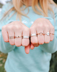 Worthy ring shown among an assortment of rings worn on both hands