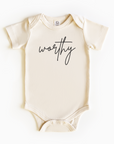 Baby wearing “Worthy” affirmation bodysuit – Christian script design organic cotton outfit by Lumiere Vive