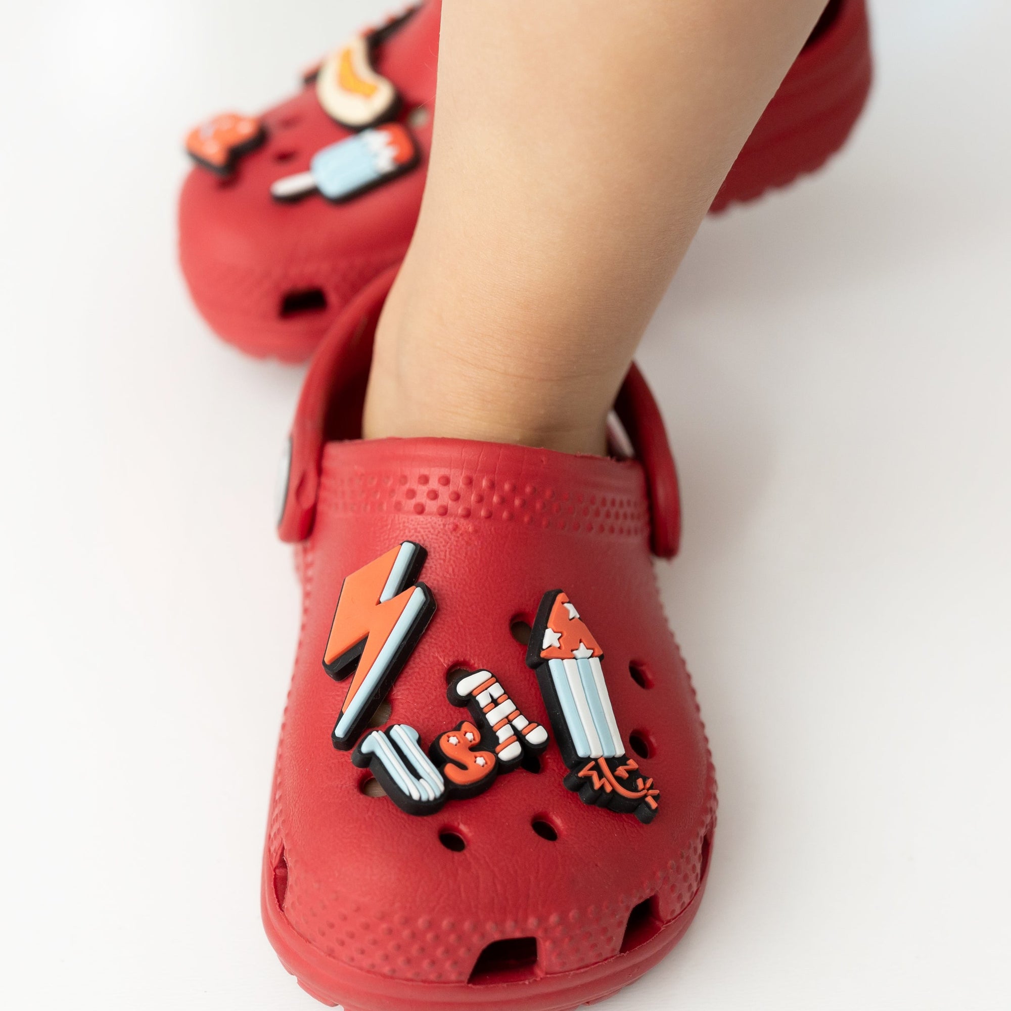 Red children's shoes with cartoon character designs on a white background