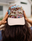 Close-up of the I’m Sticking With Jesus floral hat with cream script lettering and a light pink brim