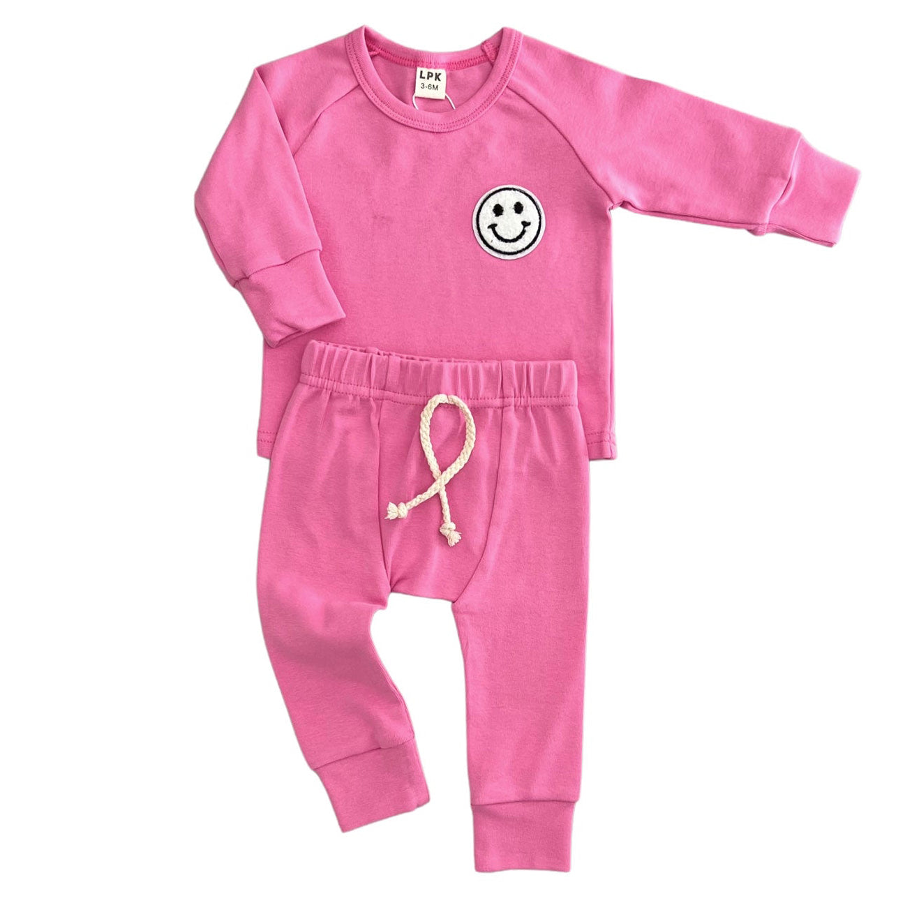 Pink baby outfit with smiley face design on a white background