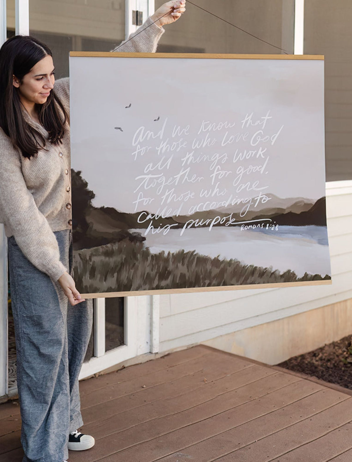 Woman holding the large All Things Work Together landscape scripture print to show its scale.