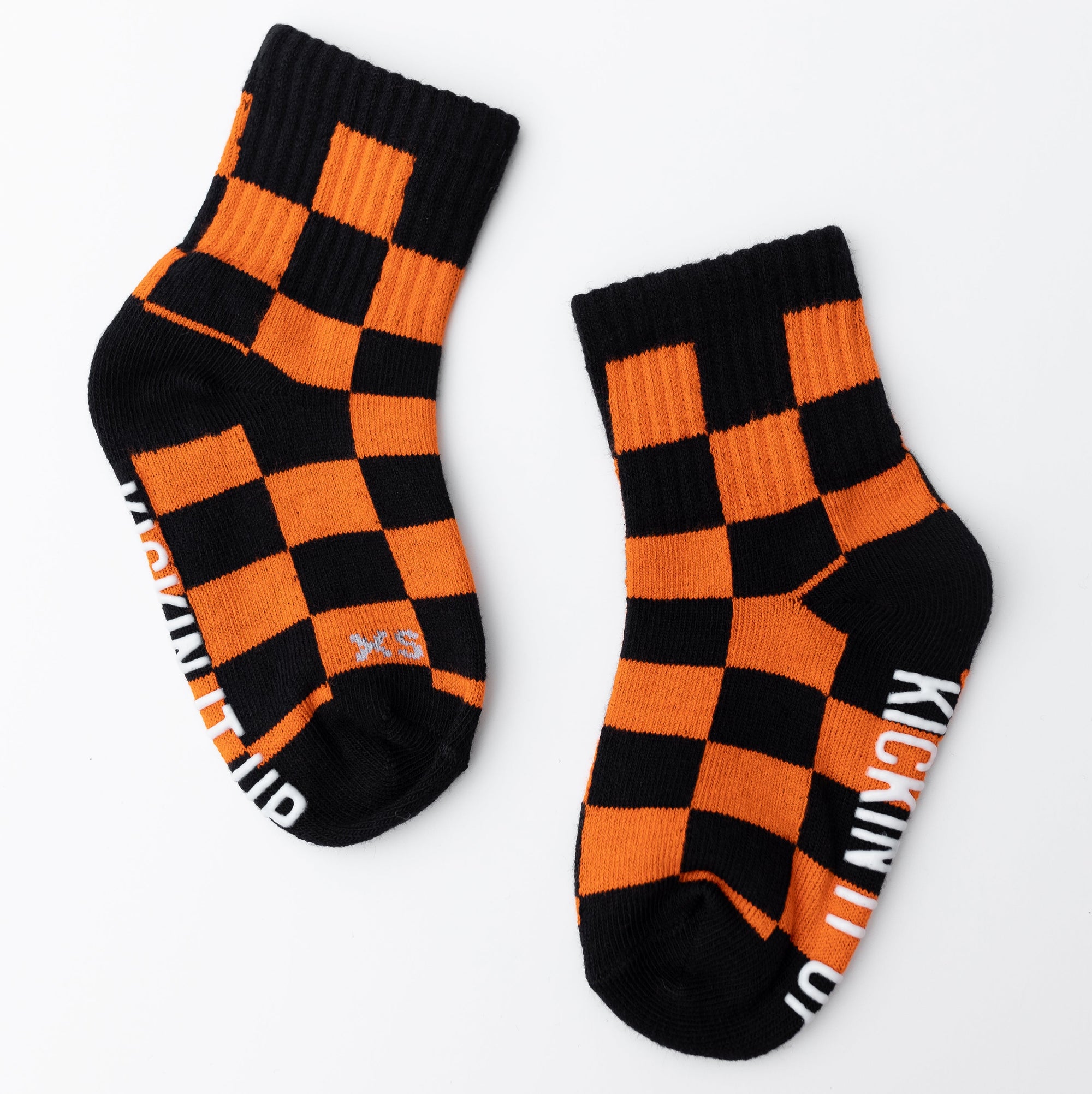 Pair of black and orange checkered socks with visible branding on a white background