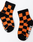 Pair of black and orange checkered socks with visible branding on a white background