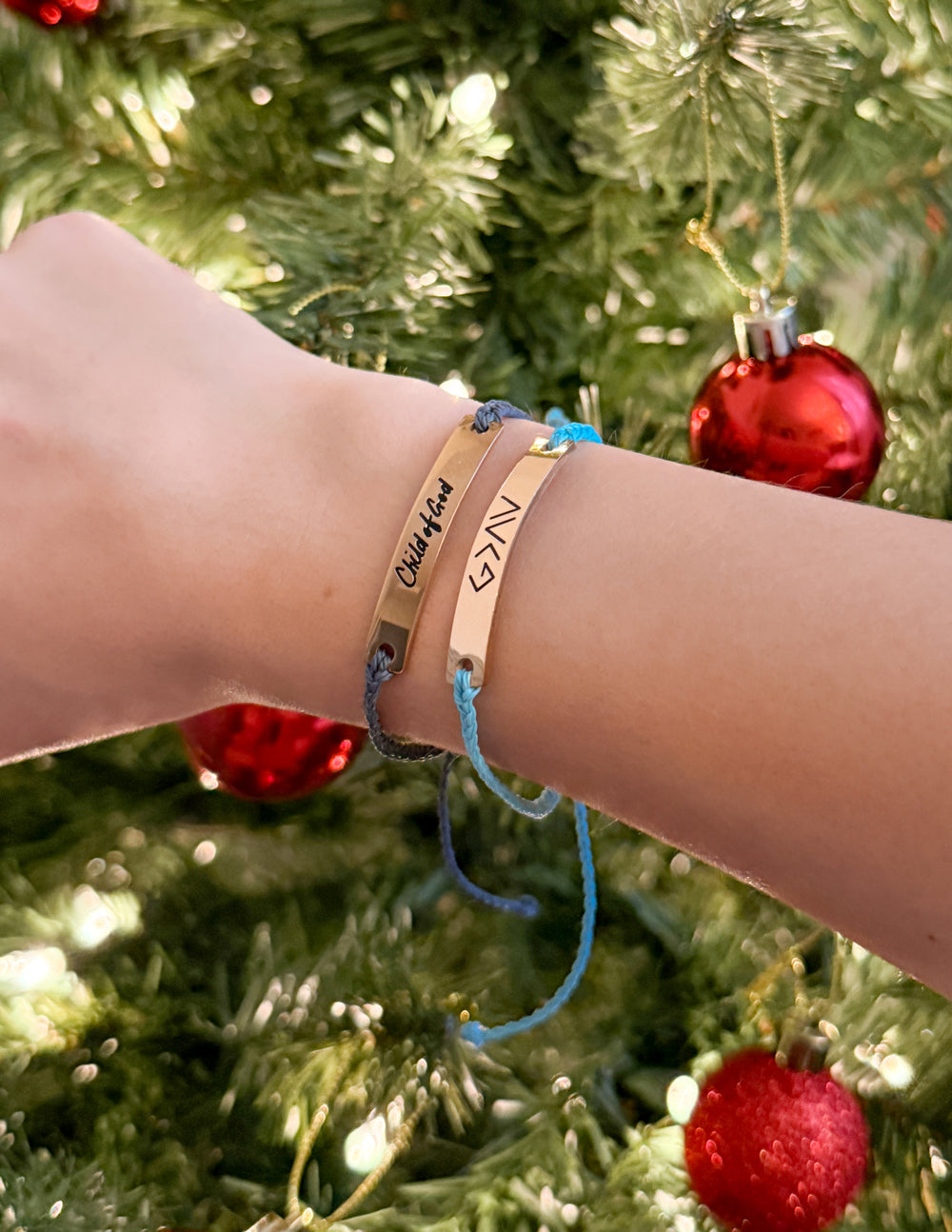 Blue Highs and Lows bracelet styled with another bracelet in front of a decorated Christmas tree.