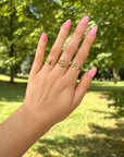 Textured Wrapped Cross Gold-Tone Ring styled with several rings on a hand outdoors