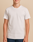 Young boy wearing a white Jerzees 29BR Dri Power 50/50 Youth T-Shirt on a neutral beige studio background — soft cotton-poly blank ideal for custom printing by Lumiere Vive.