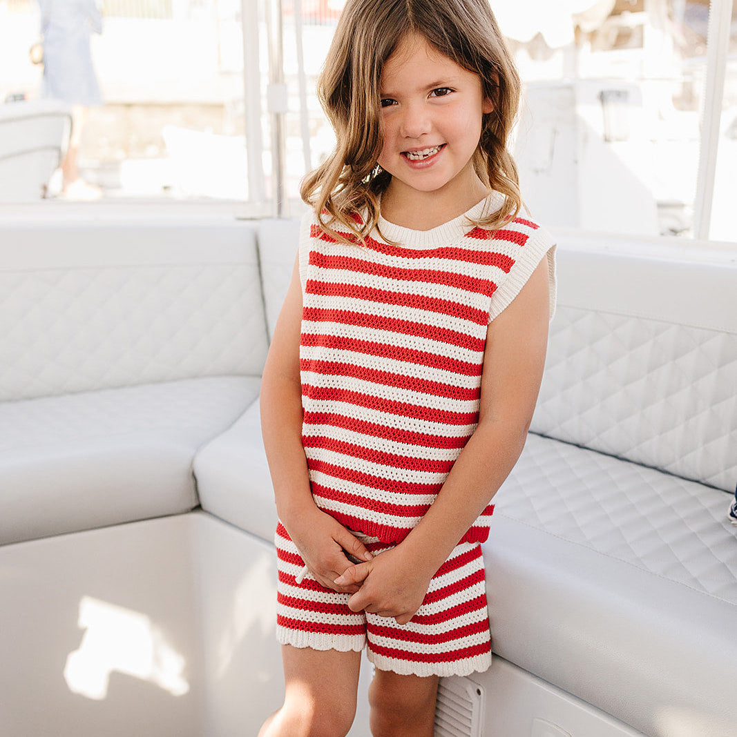 Young girl in a red and white striped outfit on a boat