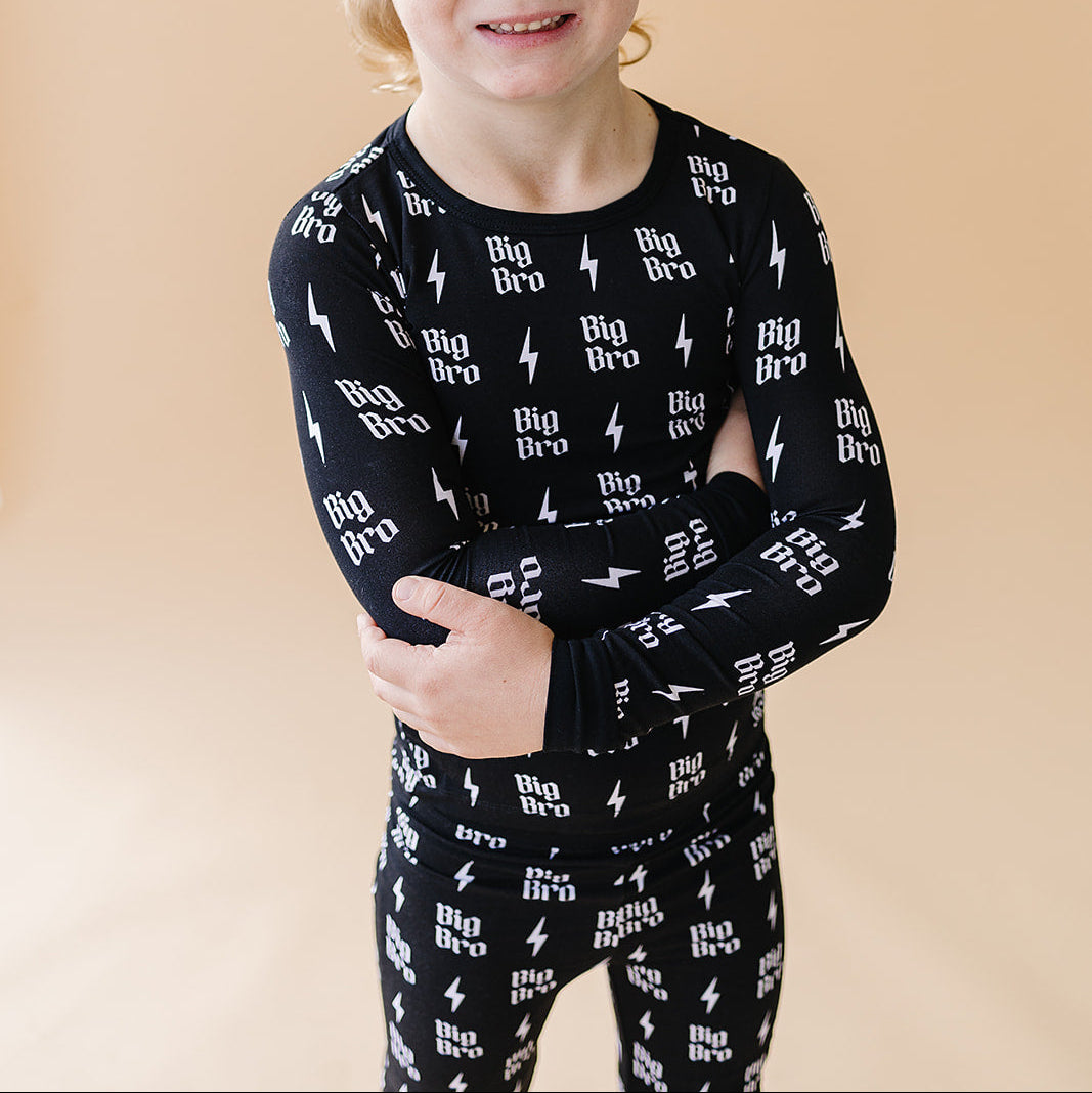 Child wearing a black outfit with 'Big Bro' text on a beige background