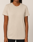 Dark-skinned female model wearing a neutral Bella + Canvas 3001C Unisex Jersey T-Shirt on a beige background — soft cotton blank ideal for custom printing by Lumiere Vive.