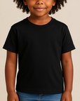Young girl wearing a black Next Level 3312 Youth CVC T-Shirt on a neutral beige studio background — soft cotton-poly blank ideal for custom printing by Lumiere Vive.