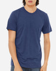 Male model wearing a navy Bella + Canvas 3413C Triblend T-Shirt on a white background — soft lightweight tri-blend blank ideal for custom printing by Lumiere Vive.