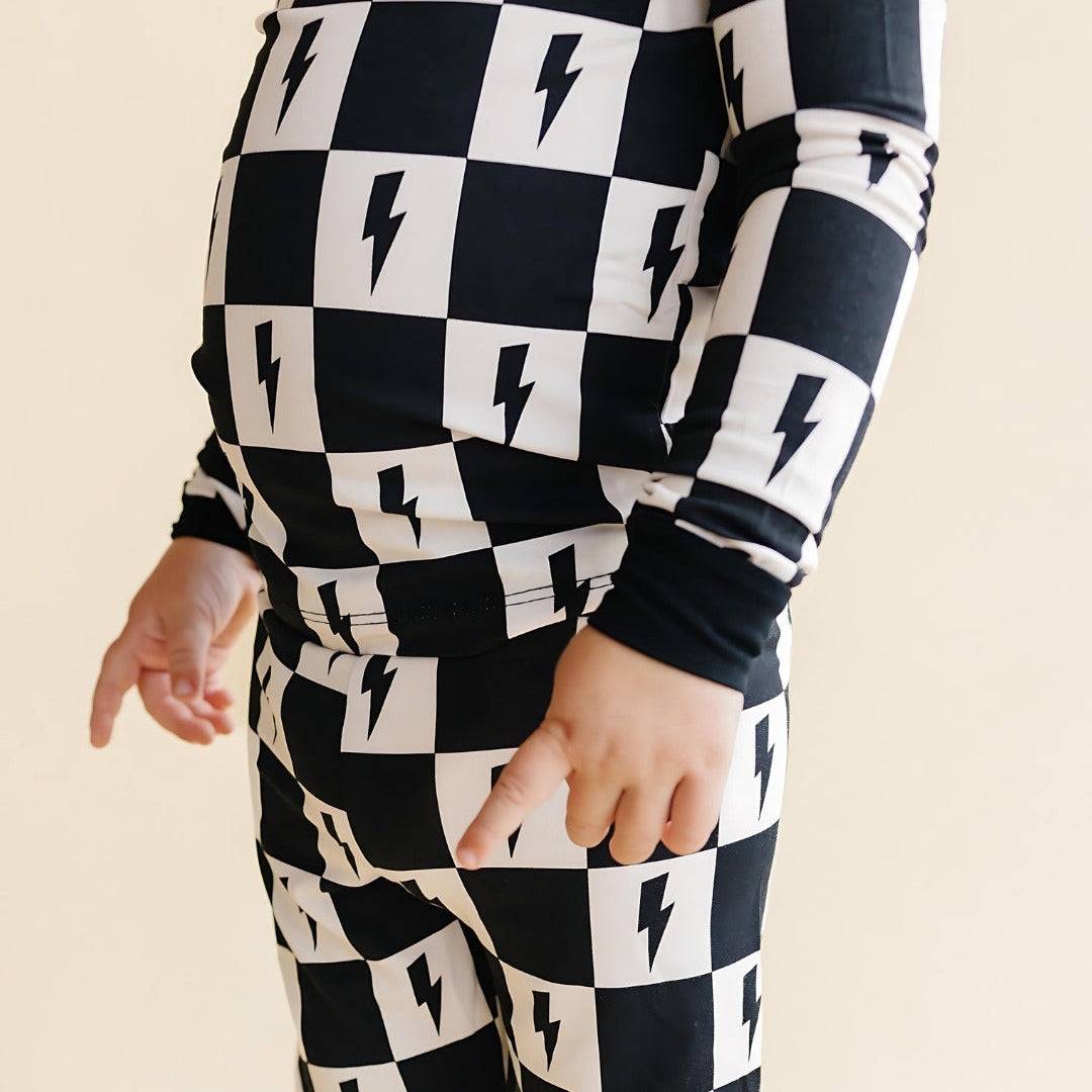 Black and white checkered outfit with lightning bolt pattern on a beige background