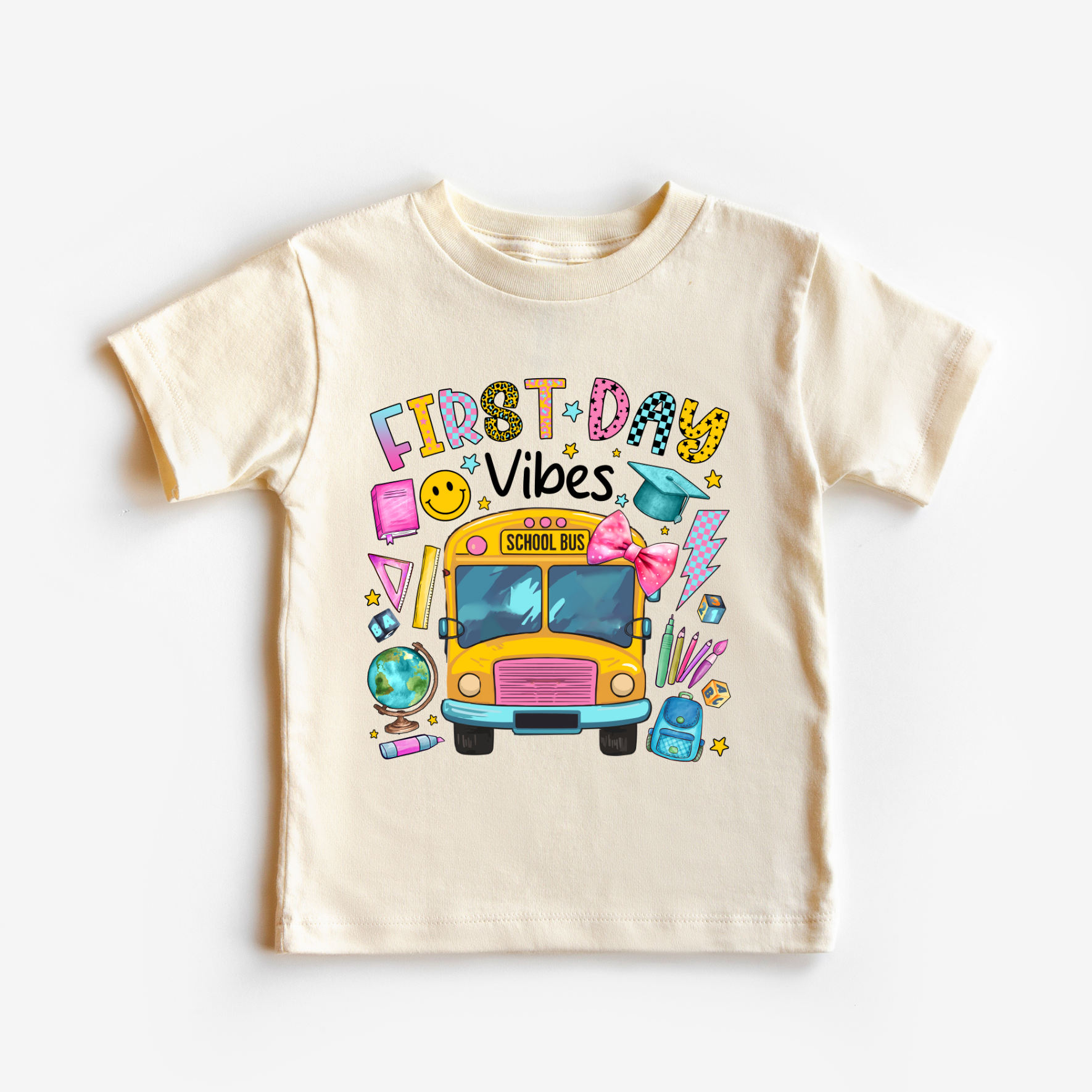Children's t-shirt with 'First Day Vibes' design featuring a school bus and colorful elements on a white background.