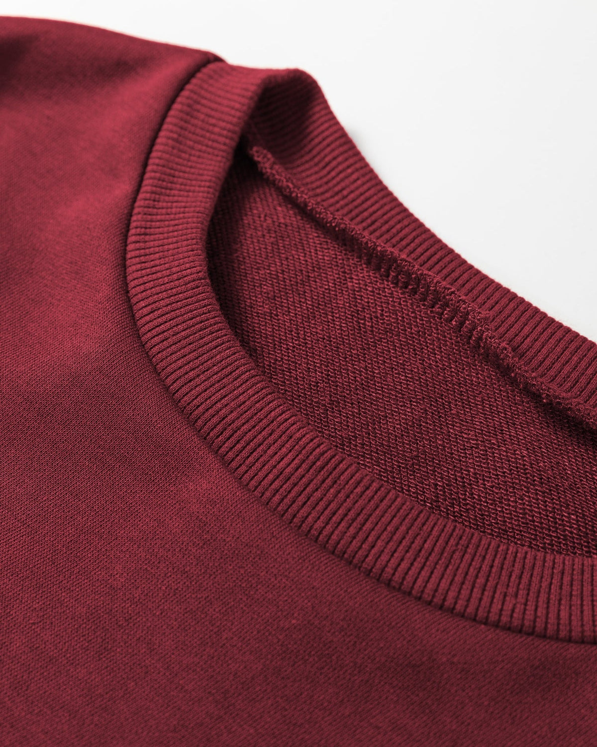 Close-up of the burgundy Sportie pullover showing its ribbed crew neckline.