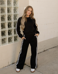 Front view of black striped pullover and matching sweatpants