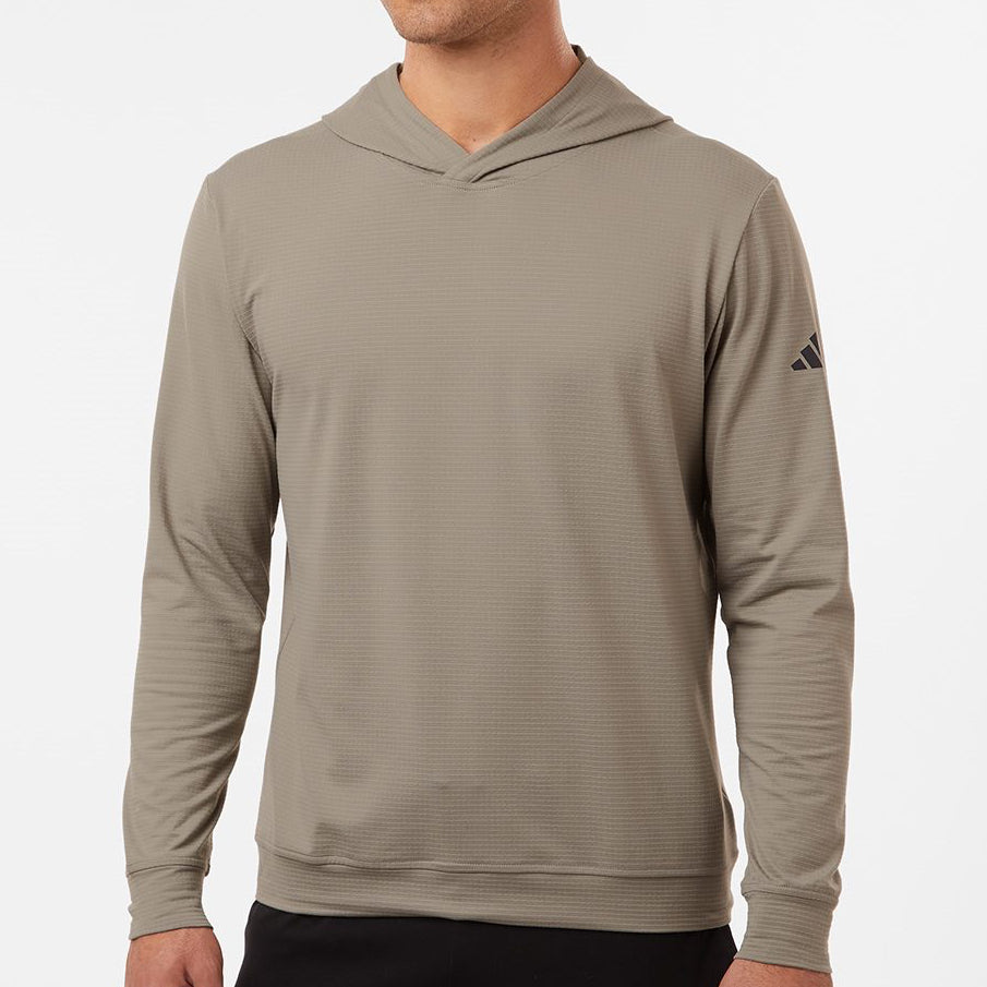 Man wearing a tan Adidas A2009 Ultimate Elevated Hoodie on a neutral background — premium performance fleece hoodie ideal for embroidery or custom branding by Lumiere Vive.