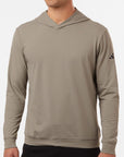 Man wearing a tan Adidas A2009 Ultimate Elevated Hoodie on a neutral background — premium performance fleece hoodie ideal for embroidery or custom branding by Lumiere Vive.