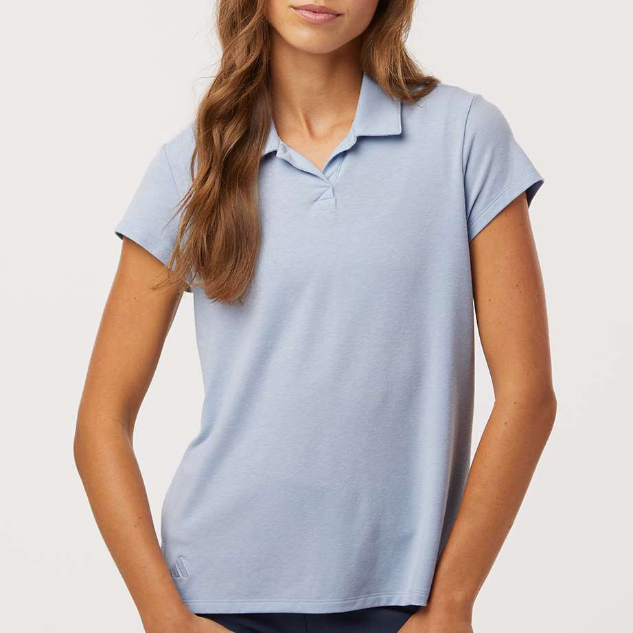 Woman wearing a light blue Adidas A690 Women’s Blend Polo on a neutral background — premium moisture-wicking performance polo designed for embroidery and custom branding by Lumiere Vive.