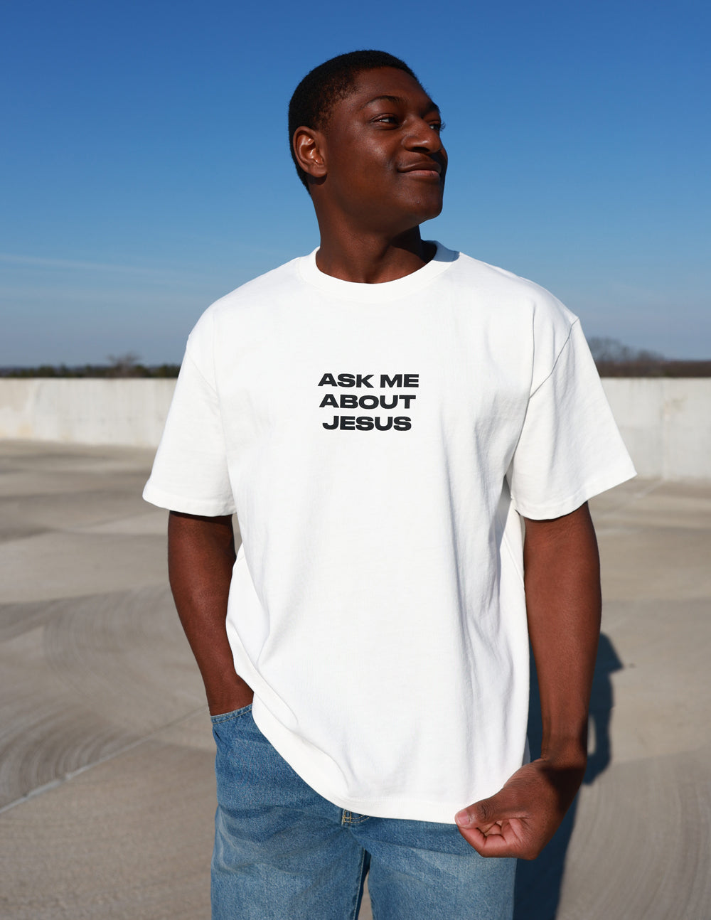 Model wearing cream Ask Me About Jesus heavyweight tee with jeans
