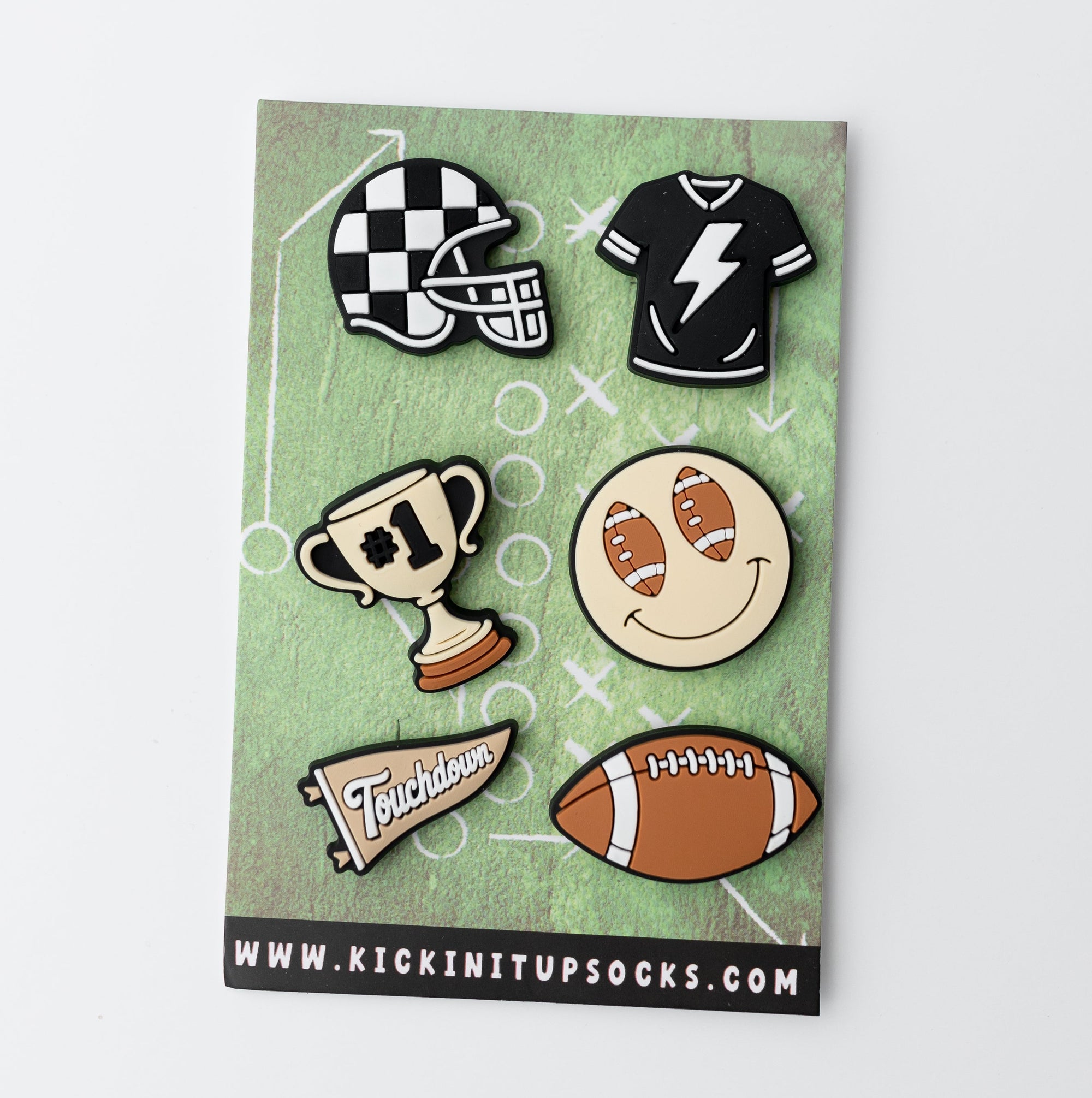 Set of sports-themed pins on a green card with 'kickin' it up socks' branding.