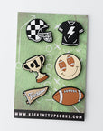 Set of sports-themed pins on a green card with 'kickin' it up socks' branding.